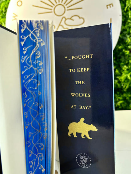 Book with decorative cover and text 'Fought to keep the wolves at bay' on a white surface.