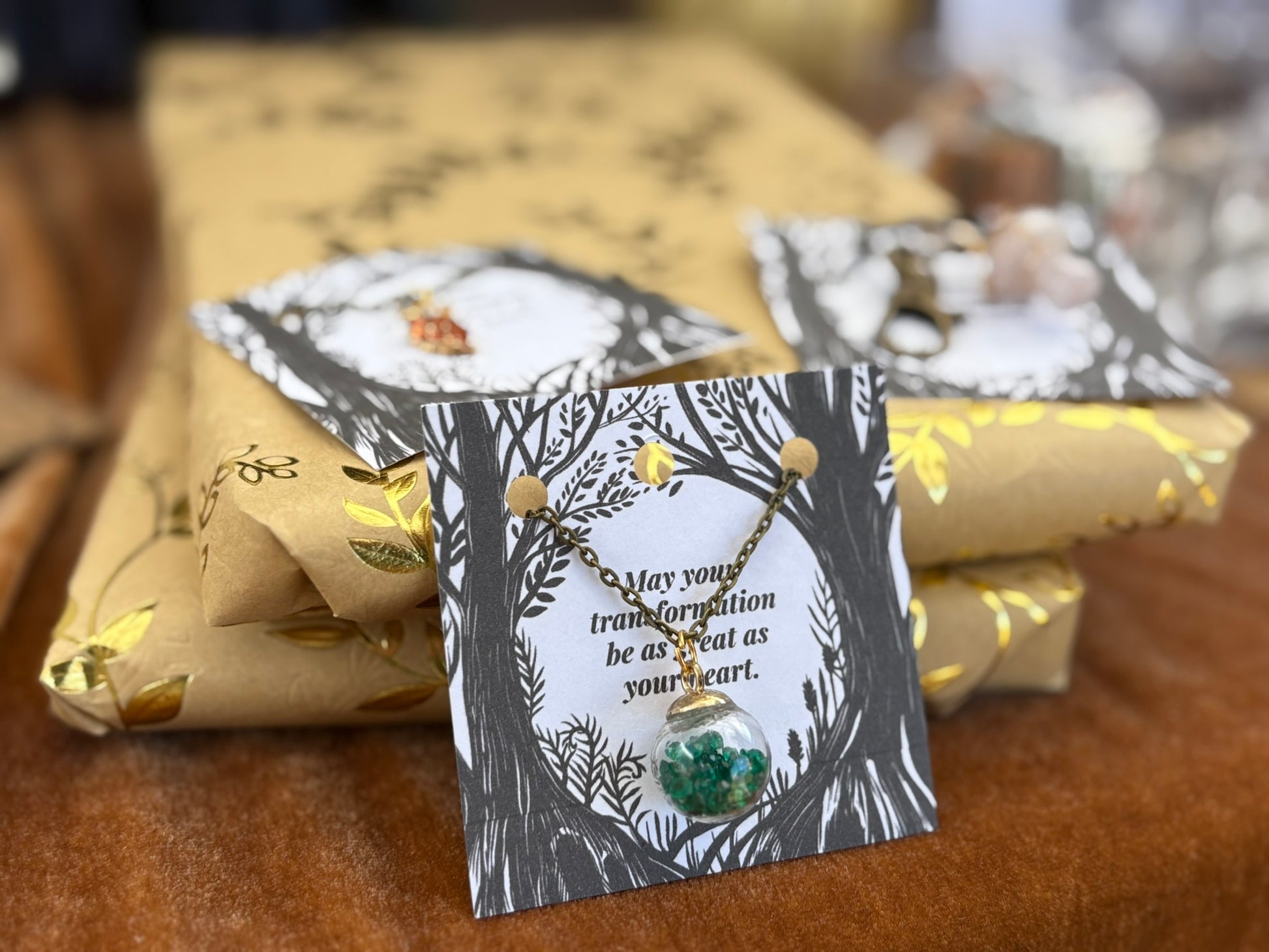 Necklace with a card on a table with wrapped gifts
