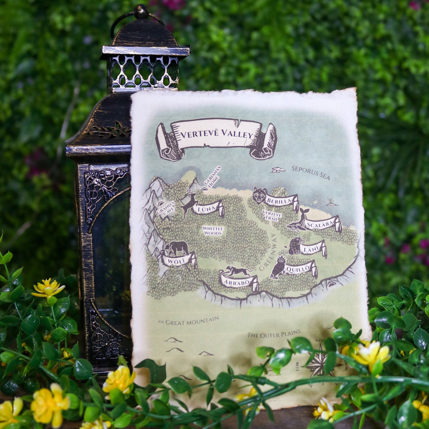 Decorative map with lantern and flowers on a wooden surface